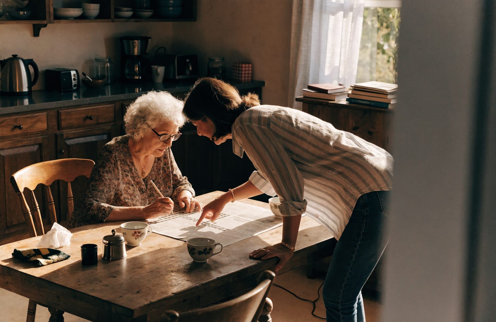 A home care administrator reviews a policy binder at a kitchen table before a survey visit